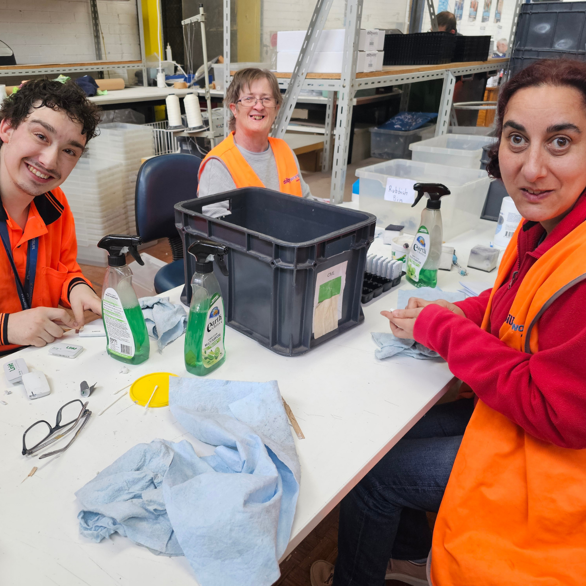 Three smiling employees clean e-tags for Transurban.